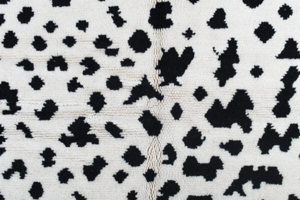 Custom Moroccan rug runner with white base and scattered black abstract Berber Moroccan rug design, handwoven from wool, featuring fringed edges for a unique Moroccan rug area.