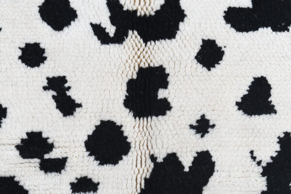 Custom Moroccan rug runner with white base and scattered black abstract Berber Moroccan rug design, handwoven from wool, featuring fringed edges for a unique Moroccan rug area.