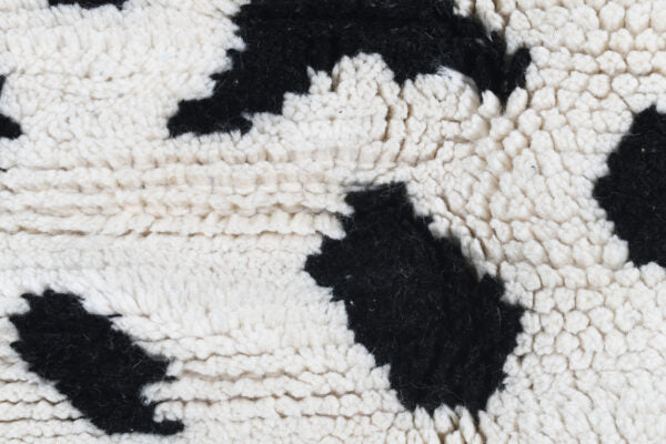 Custom Moroccan rug runner with white base and scattered black abstract Berber Moroccan rug design, handwoven from wool, featuring fringed edges for a unique Moroccan rug area.
