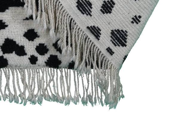 Custom Moroccan rug runner with white base and scattered black abstract Berber Moroccan rug design, handwoven from wool, featuring fringed edges for a unique Moroccan rug area.