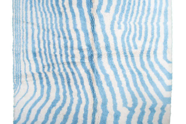 Custom Moroccan rug runner with blue and white wavy stripe Berber Moroccan rug design, handwoven from wool, featuring fringed edges for a chic Moroccan rug area.