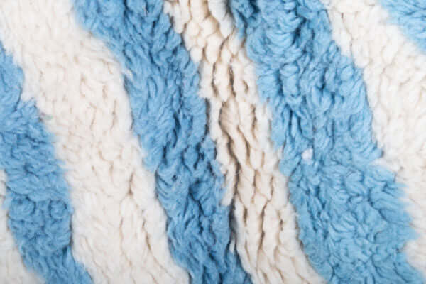 Custom Moroccan rug runner with blue and white wavy stripe Berber Moroccan rug design, handwoven from wool, featuring fringed edges for a chic Moroccan rug area.
