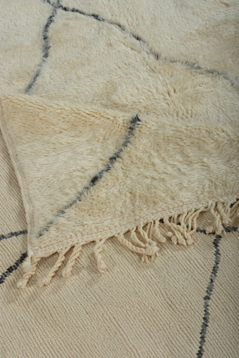 Custom Moroccan rug runner with cream base and blue diamond Berber Moroccan rug design, handwoven from wool, featuring fringed edges for a chic Moroccan rug area.
