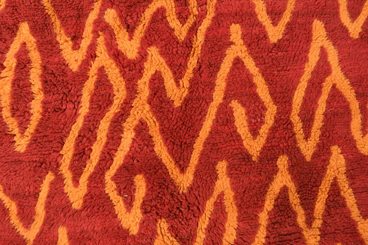 Custom Moroccan rug runner with red base and orange zigzag Berber Moroccan rug design, handwoven from wool, featuring fringed edges for a stylish Moroccan rug area.