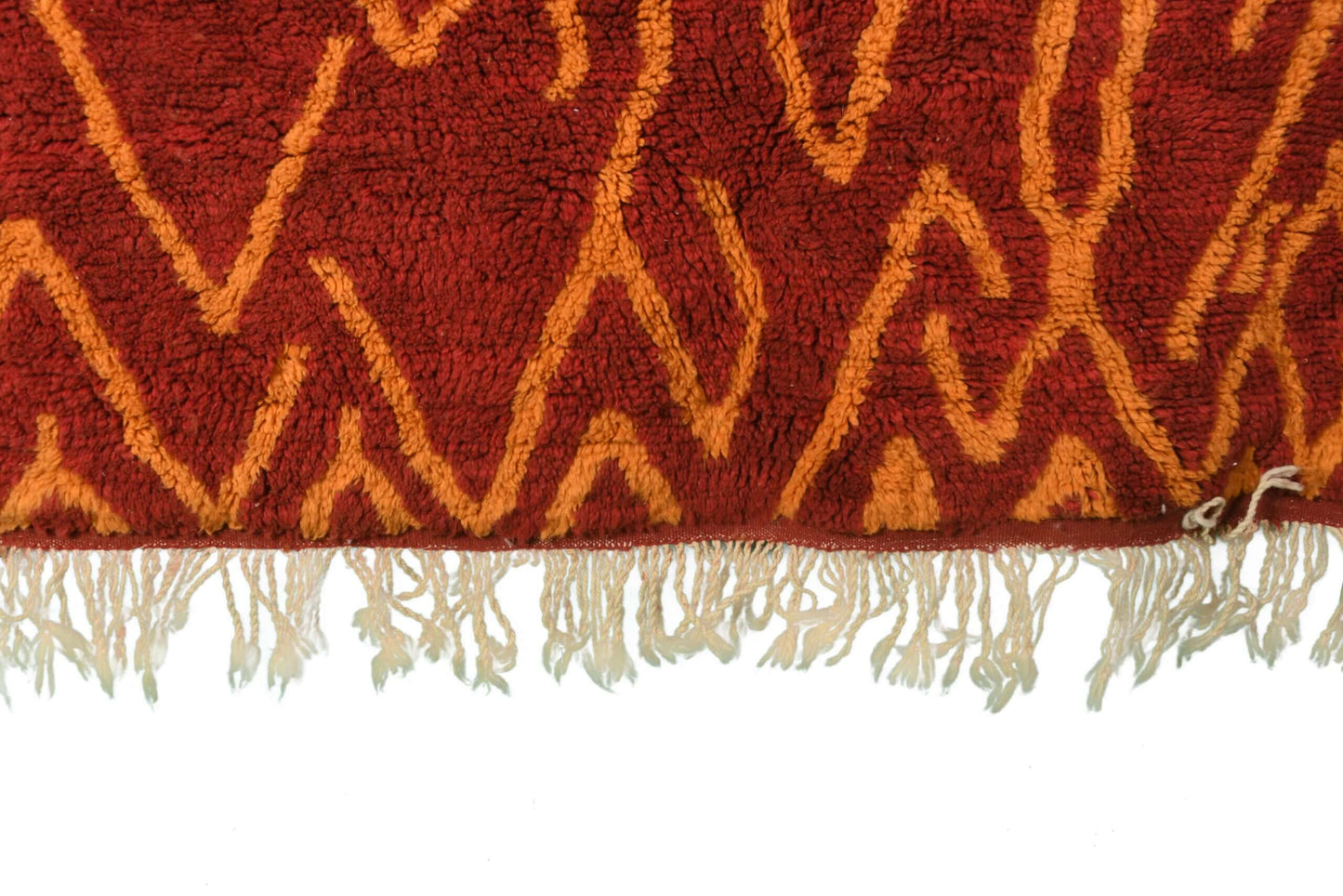 Custom Moroccan rug runner with red base and orange zigzag Berber Moroccan rug design, handwoven from wool, featuring fringed edges for a stylish Moroccan rug area.
