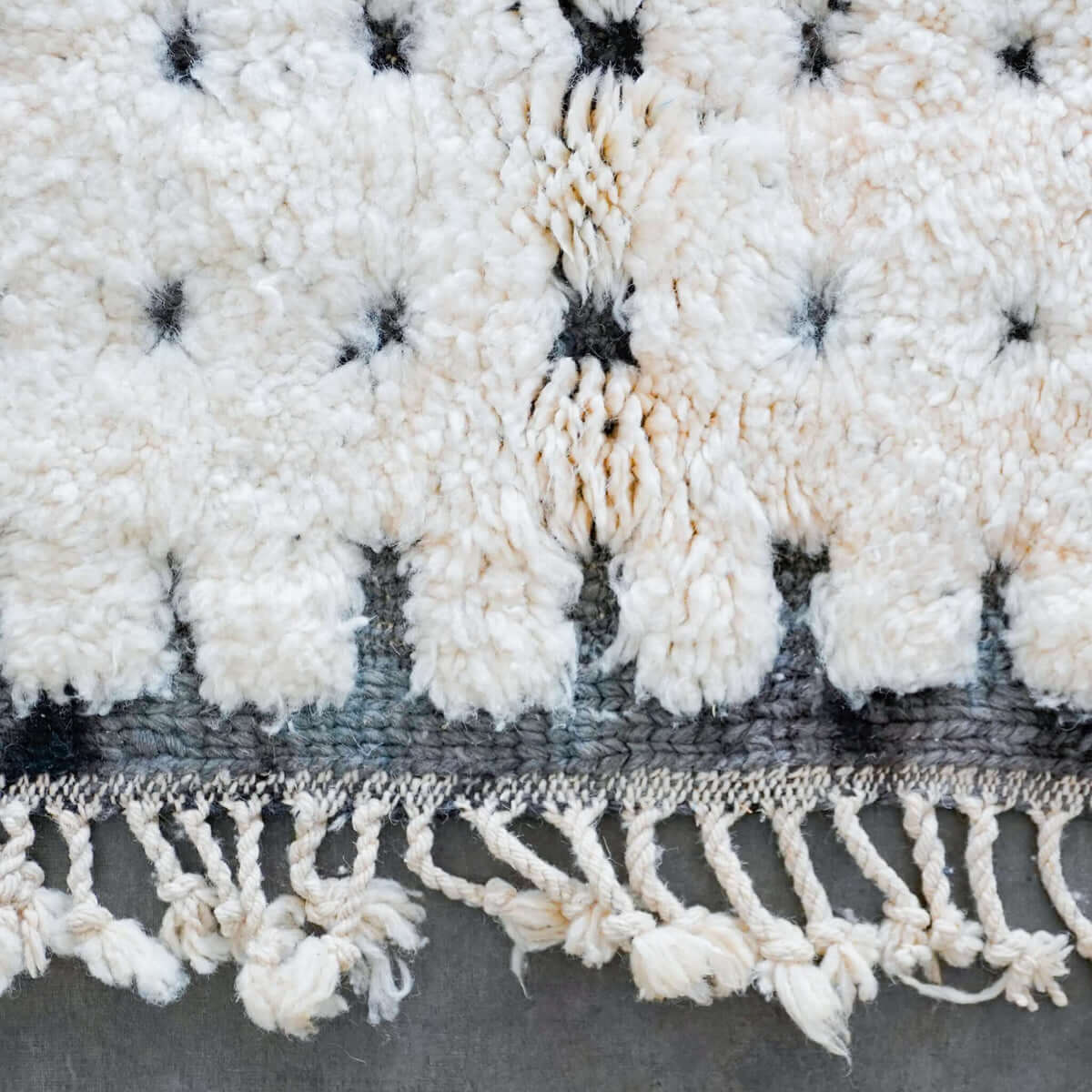 Atlasknot rug edge with hand-knotted fringe and detailed tribal knot design