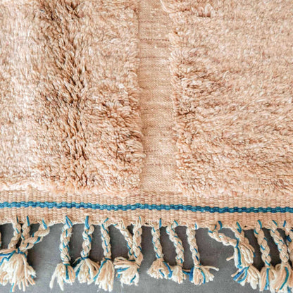 SaharaBeige rug border featuring natural wool fringe and elegant beige tribal design