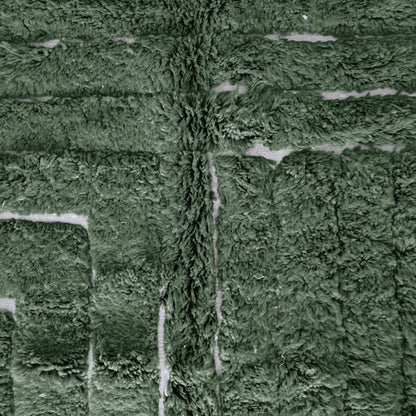 Detailed view of VerdeBer rug showing forest green wool texture and artisan knotting