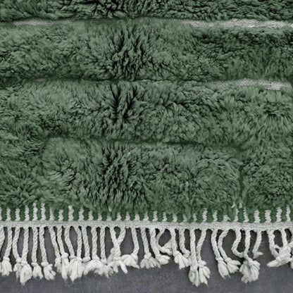 VerdeBer rug border with wool fringe and subtle tribal motifs in green tones