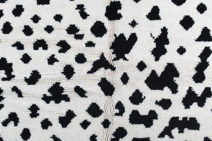 Custom Moroccan rug runner with white base and scattered black abstract Berber Moroccan rug design, handwoven from wool, featuring fringed edges for a unique Moroccan rug area.