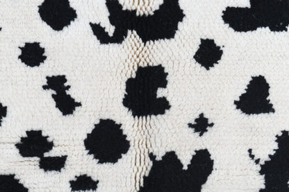 Custom Moroccan rug runner with white base and scattered black abstract Berber Moroccan rug design, handwoven from wool, featuring fringed edges for a unique Moroccan rug area.