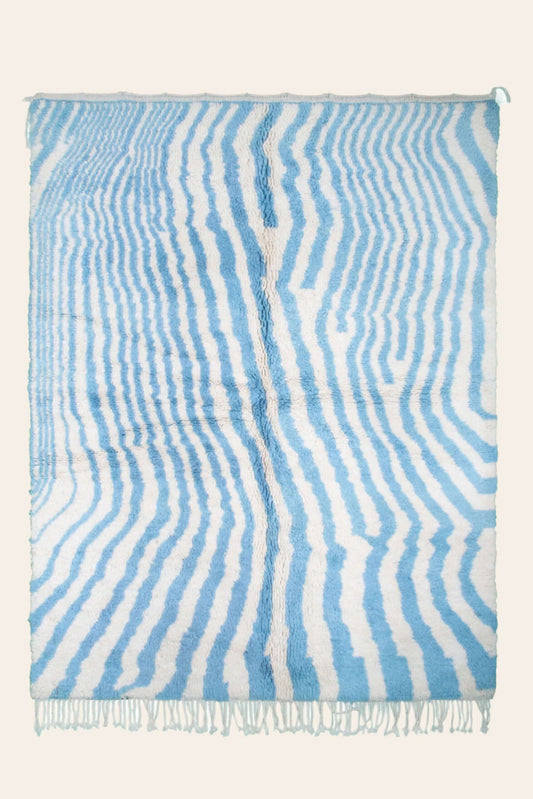 Custom Moroccan rug runner with blue and white wavy stripe Berber Moroccan rug design, handwoven from wool, featuring fringed edges for a chic Moroccan rug area.