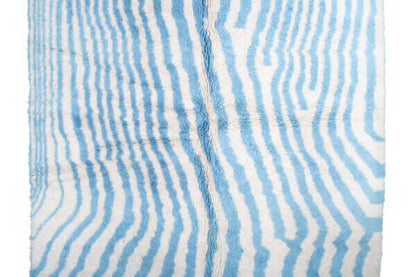 Custom Moroccan rug runner with blue and white wavy stripe Berber Moroccan rug design, handwoven from wool, featuring fringed edges for a chic Moroccan rug area.