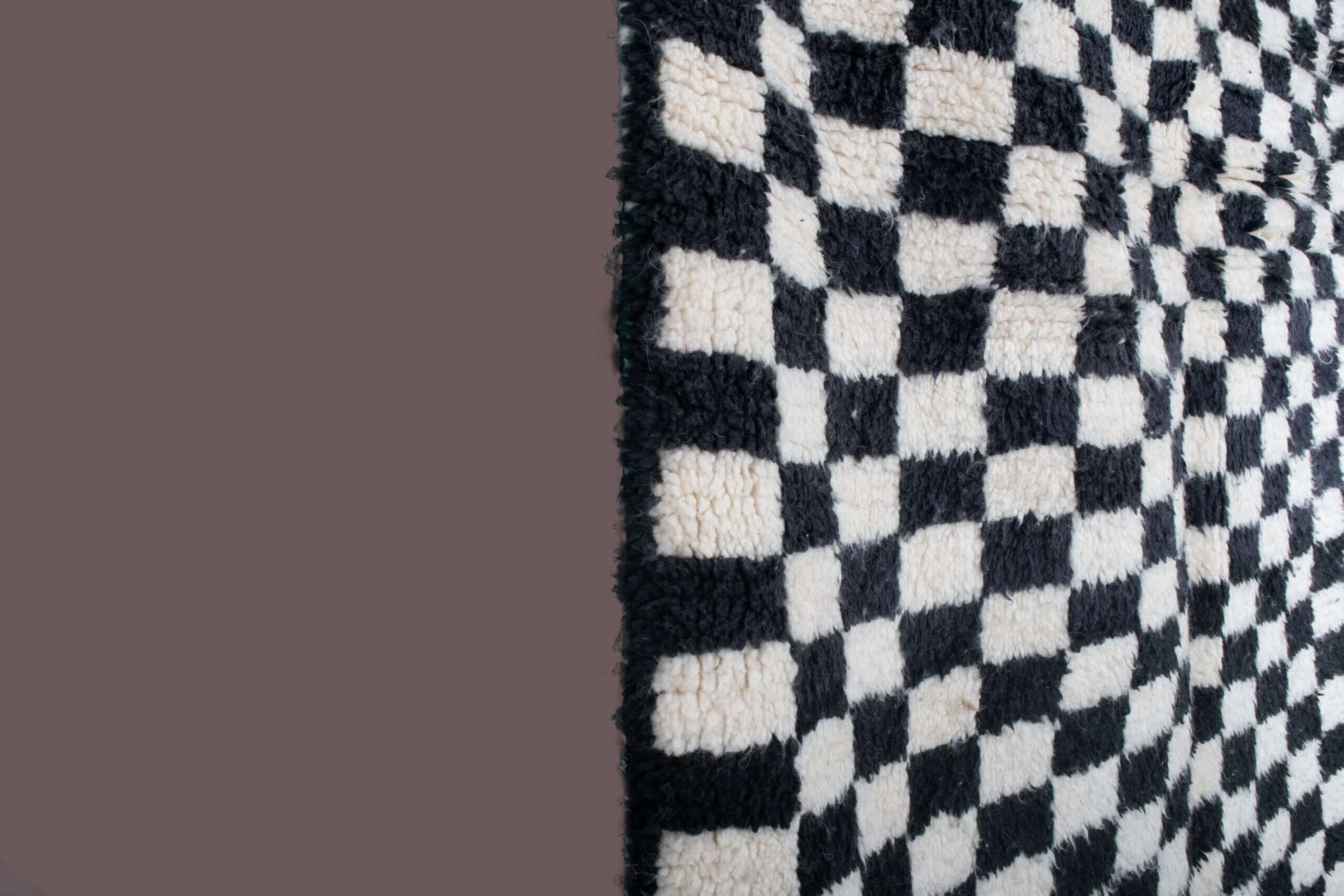 Custom Moroccan rug runner with black and white checkered Berber Moroccan rug design, handwoven from wool, featuring fringed edges for a striking Moroccan rug area.
