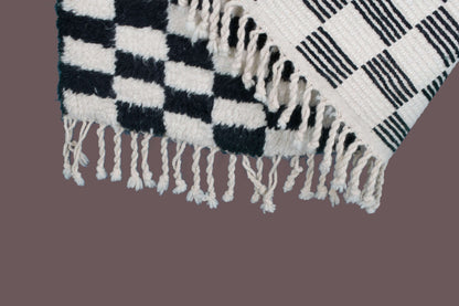 Custom Moroccan rug runner with black and white checkered Berber Moroccan rug design, handwoven from wool, featuring fringed edges for a striking Moroccan rug area.