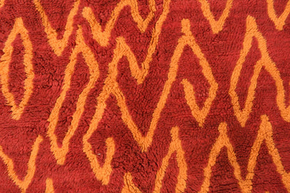 Custom Moroccan rug runner with red base and orange zigzag Berber Moroccan rug design, handwoven from wool, featuring fringed edges for a stylish Moroccan rug area.