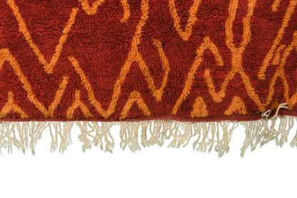 Custom Moroccan rug runner with red base and orange zigzag Berber Moroccan rug design, handwoven from wool, featuring fringed edges for a stylish Moroccan rug area.