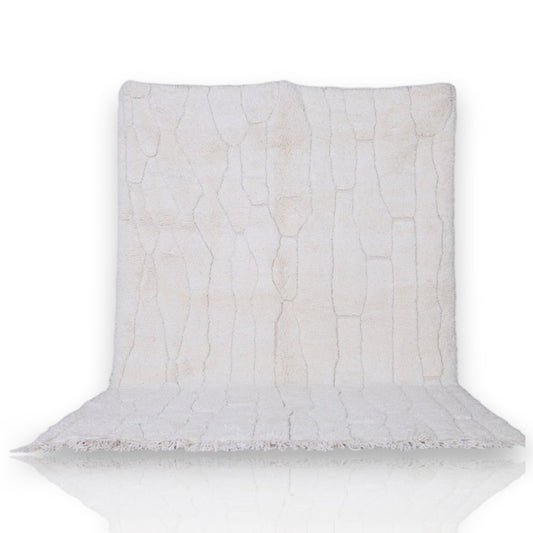 white Beni Ourain rug with geometric pattern and fringed edges, suitable for floor or wall display.